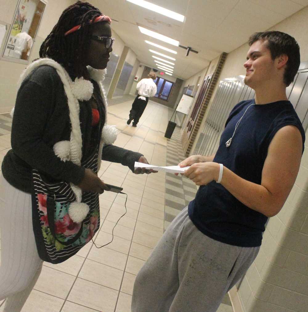 Senior Joe Ridenour (left) picks up a paper in a random act of kindness. National Kindness Day is November 13.