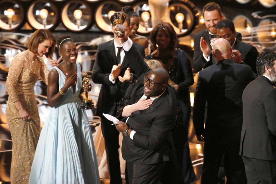 Steve McQueen pumps his fist and trophy into the air as 12 Years a Slave celebrates on stage during the 86th annual Academy Awards on Sunday, March 2.