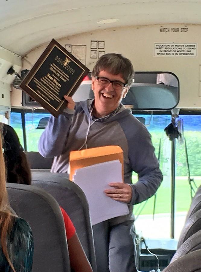 Student Publication advisor Tom Hayes shows his students his Hall of Fame Plaque on the bus before the return trip from Ball State on Friday. Hayes and 43 student publication students attended the annual J-Day festivities at Ball State.