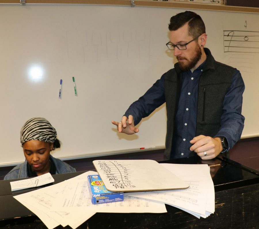 Jason David works with a student during music theory class.