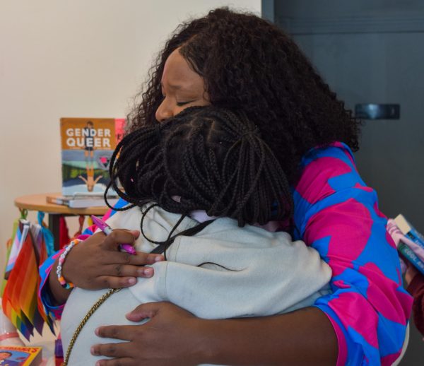 Leah Johnson hugs Khari Dennis, a senior at University High School in Carmel, Indiana, on Loudmouth Books’ opening day Saturday, Sept. 30, 2023 in Indianapolis. Dennis brought her copies of Johnson’s books “You Should See Me in a Crown” and “Rise to the Sun” for Johnson to sign.